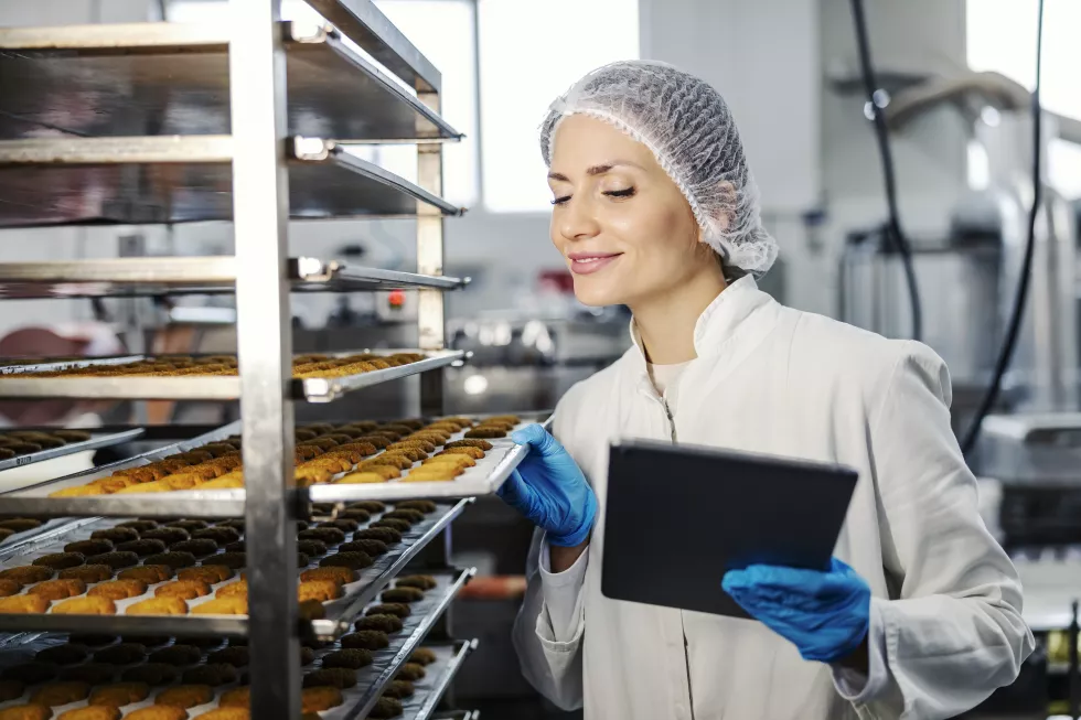 satisfied-female-food-factory-inspector-with-tablet-checking-baking-products-quality