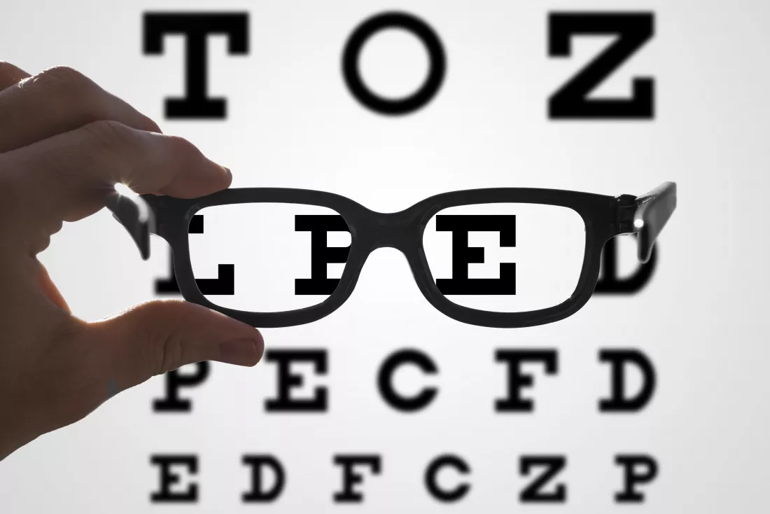cropped-hand-person-holding-eyeglasses-against-text