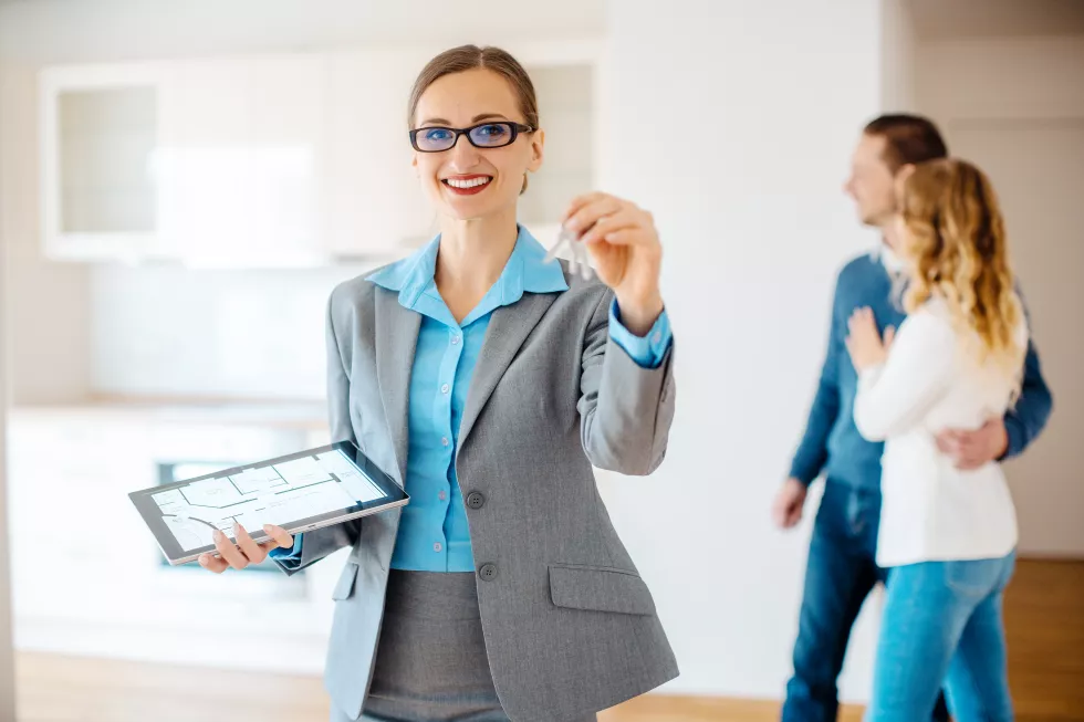 portrait-smiling-real-estate-agent-holding-key
