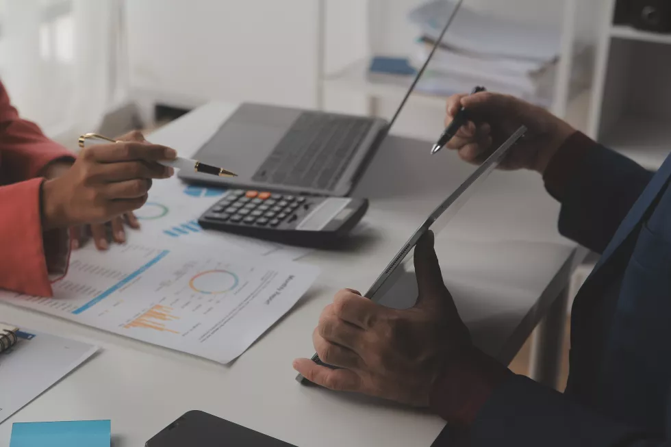 close-up-business-woman-using-calculator-laptop-math-finance-wooden-desk-tax-accounting-statistics-analytical-research-concept