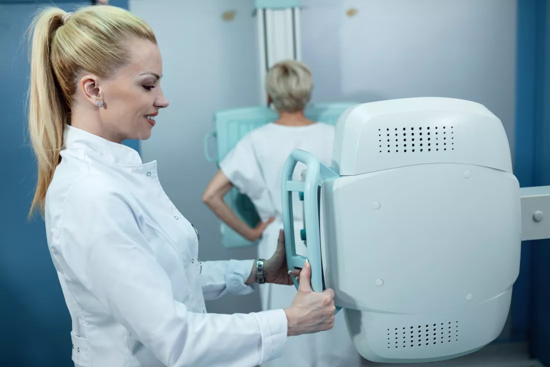 mid-adult-smiling-nurse-taking-xray-patient-clinic