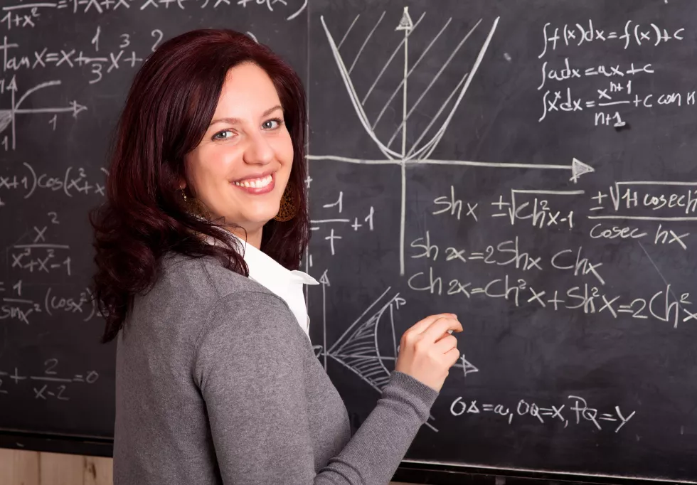 portrait-smiling-teacher-writing-blackboard