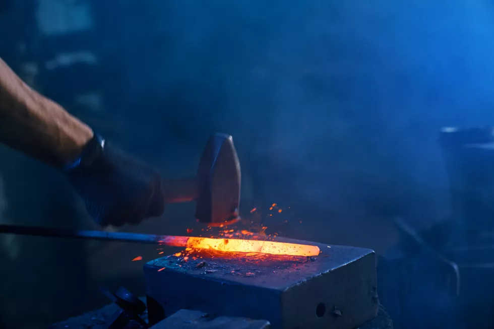 close-up-strong-male-hands-forging-molten-metal-anvil