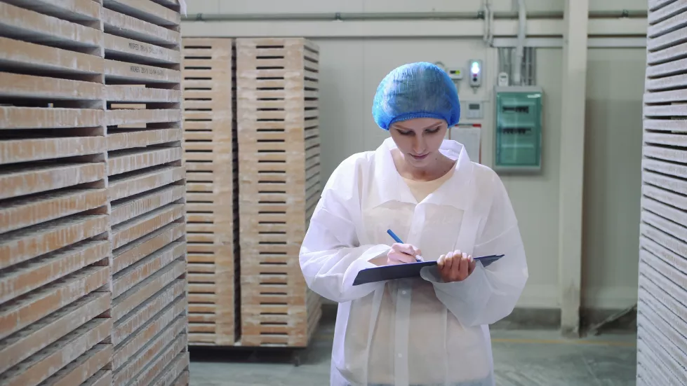 woman-writing-document-while-working-factory