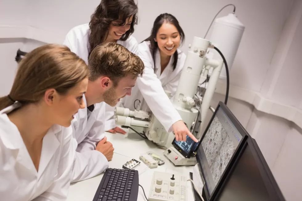 biochemistry-students-using-large-microscope-computer