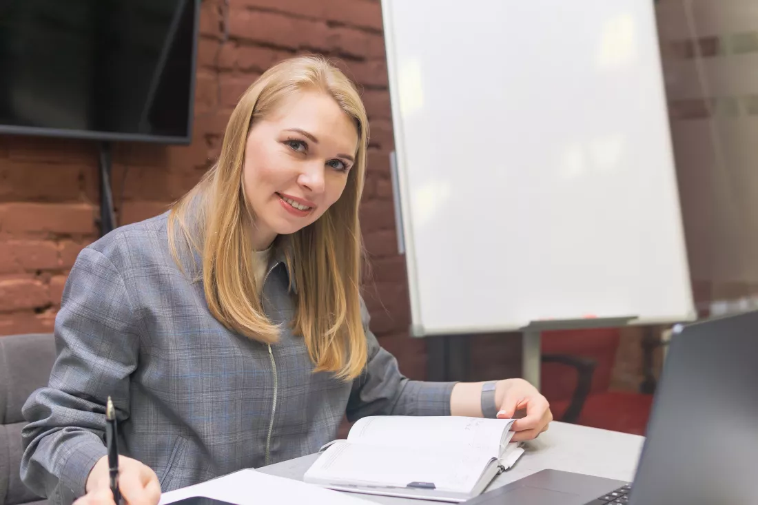 young-businesswoman-teacher-sitting-desk-office-writing-notes