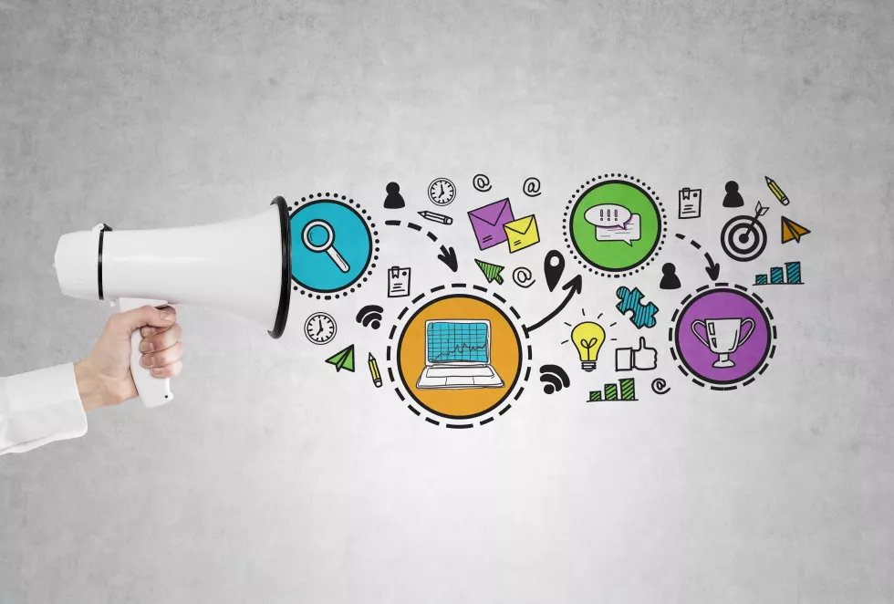 close-up-hand-holding-megaphone-near-concrete-wall-with-business-prize-scheme-drawn-it