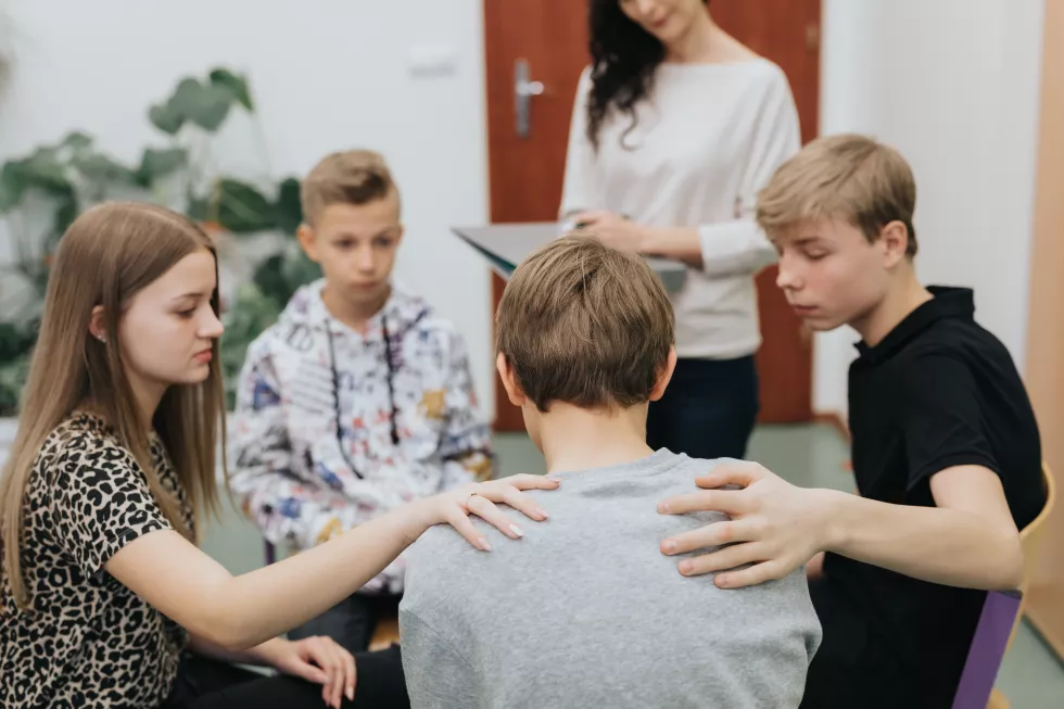 group-teenagers-sitting-circle-comforts-colleague-class-with-psychologist(1)