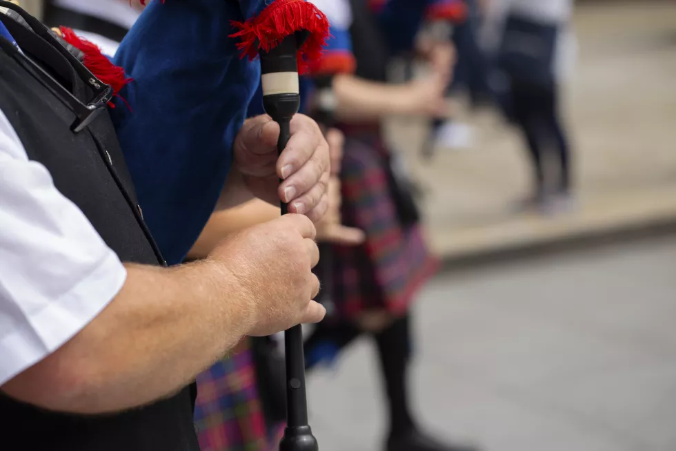 midsection-musician-playing-bagpipe-street-city