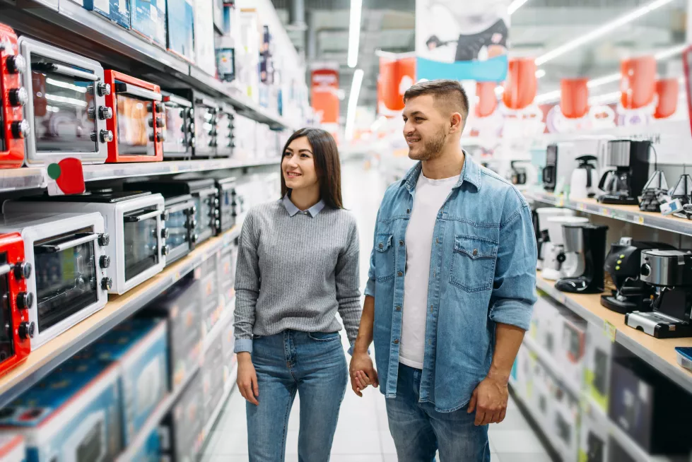 couple-looking-shelf-with-electric-ovens-supermarket