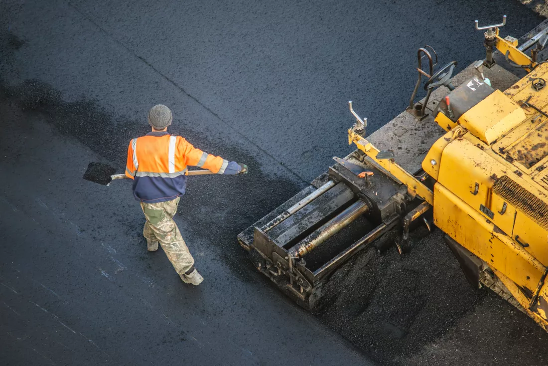 workers-lay-new-asphalt-coating-using-hot-bitumen-work-heavy-machinery-paver-top-view