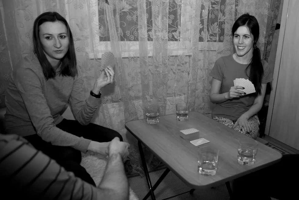 smiling-friends-playing-cards-while-sitting-table-home