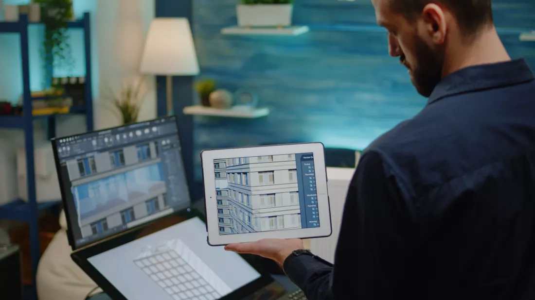 architect-holding-digital-tablet-with-building-model