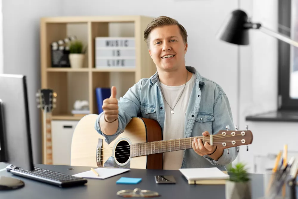 happy-man-with-guitar-showing-thumbs-up-home