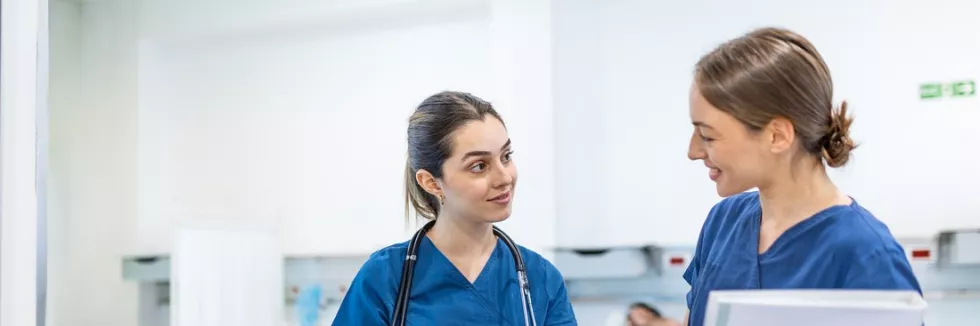 Nursing-II-stopien-test-dwie-pielegniarki-omawiaja-opieke-na-oddziale