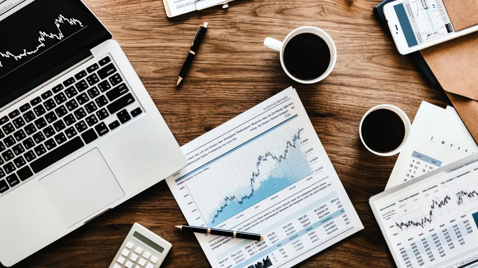 top-view-wooden-desk-with-laptop-two-cups-coffee-calculator-pen