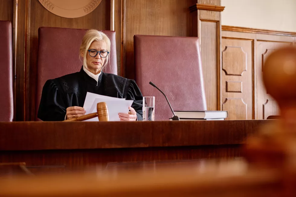 experienced-female-judge-black-gown-reading-juridical-paper-documents