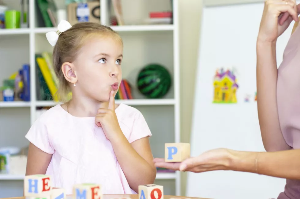 speech-therapist-teaches-girl-say-letter