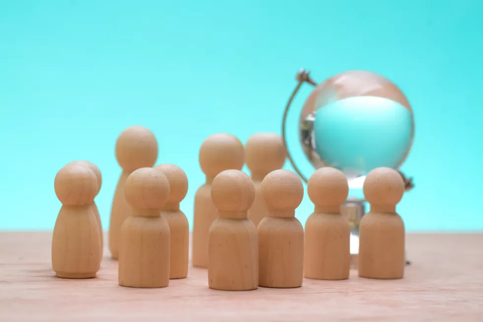 wooden-figures-encircling-together-highlighted-synergy-teammates-emphasizing-strategic-vision-needed-navigate-complexities-global-business-landscape(1)