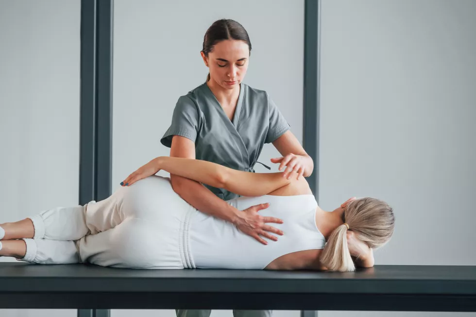 massaging-back-woman-is-health-center-getting-help-by-doctor