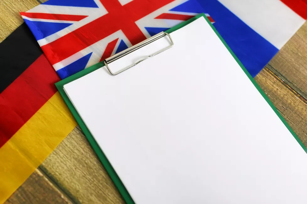 blank-paper-wooden-textural-desk-with-mobile-phone-headphones-flags