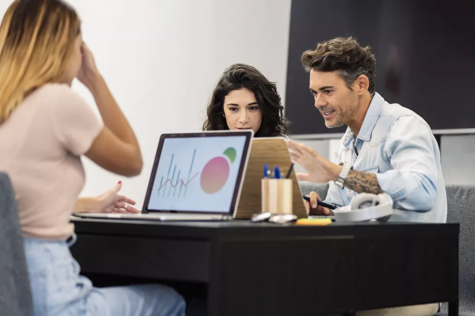 female-coworkers-coworking-with-computers-mature-man-young-caucasian-girl