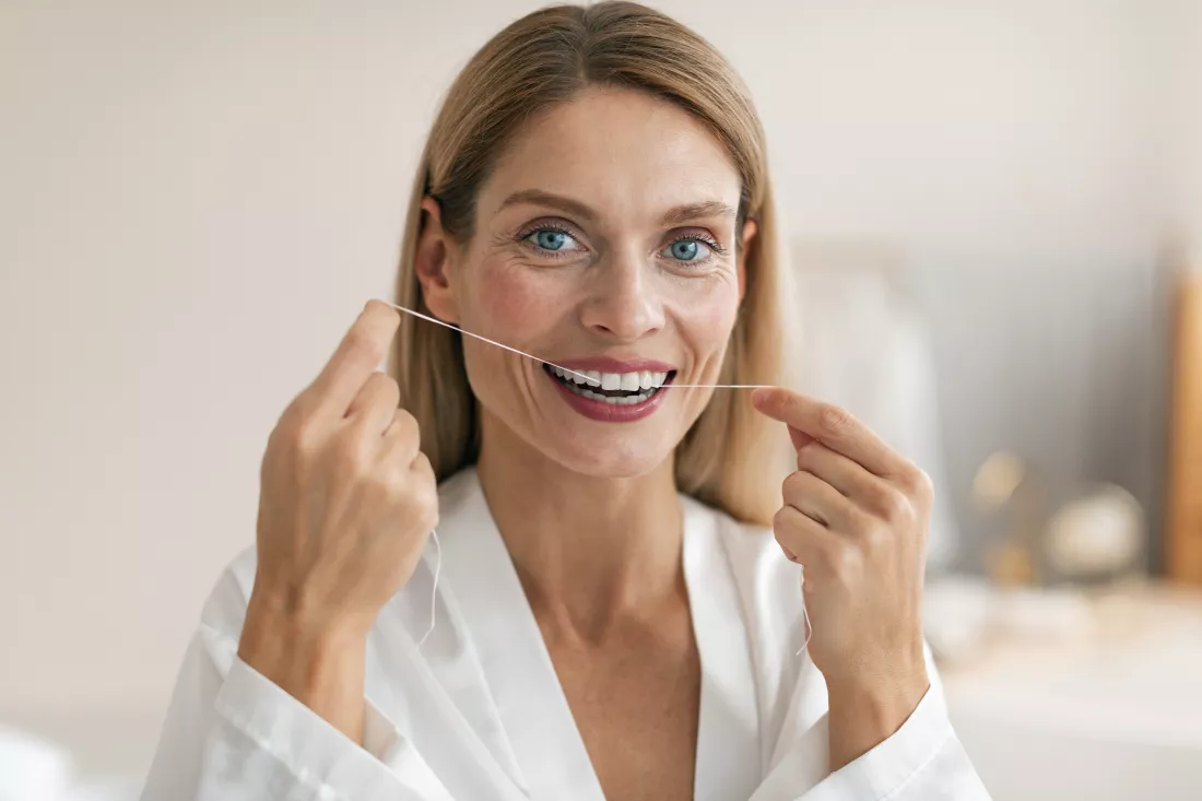 oral-health-concept-middle-aged-woman-using-dental-floss-making-daily-hygiene-posing-bathroom-interior