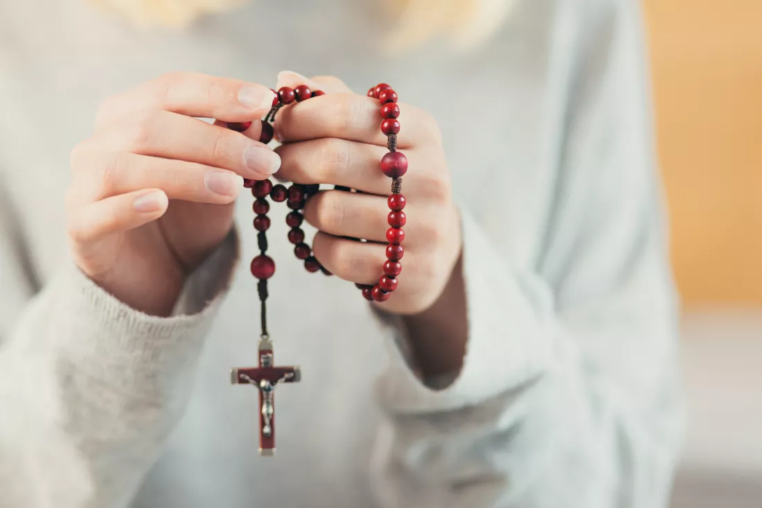 hands-woman-holding-rosary