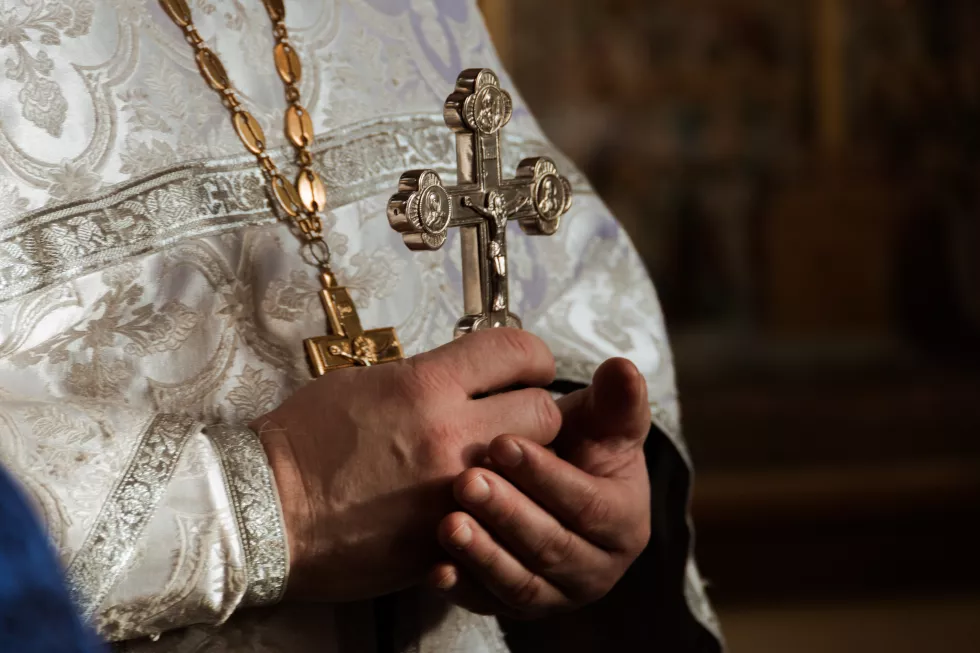 midsection-priest-holding-cross-church