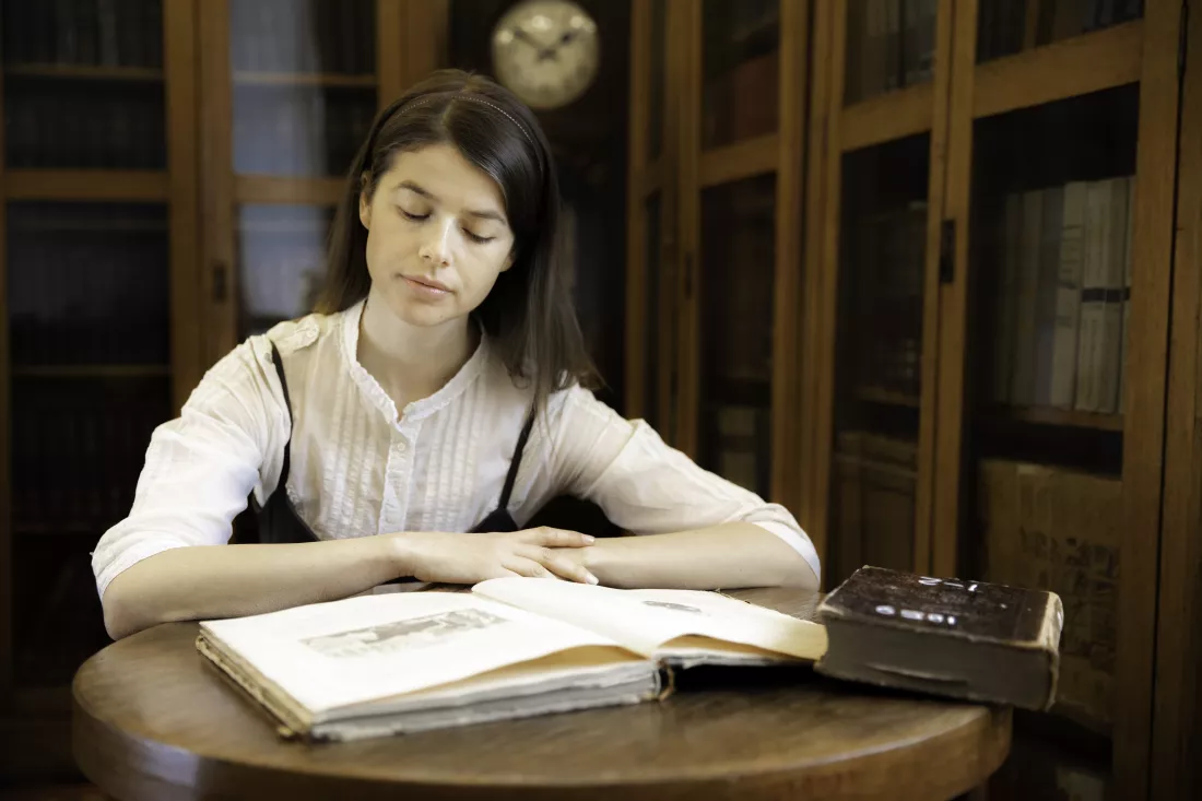 young-woman-reading-book-table
