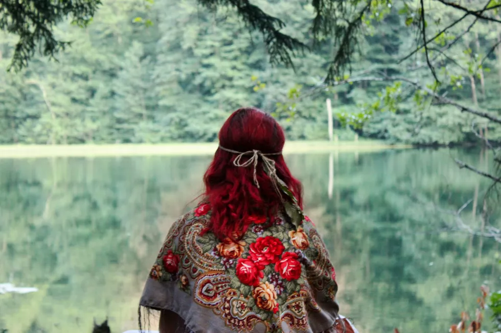 girl-with-red-hair-sitting-near-lake