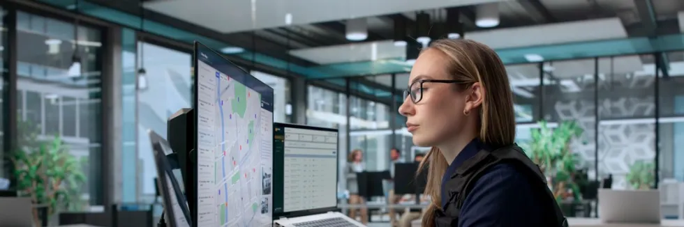 analityczka-pracuje-na-mapach-na-kilku-monitorach