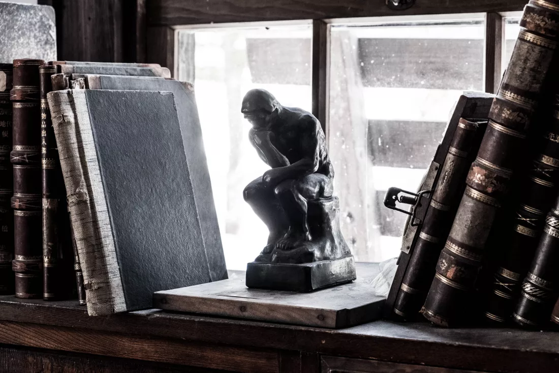 close-up-figurine-old-books-shelf