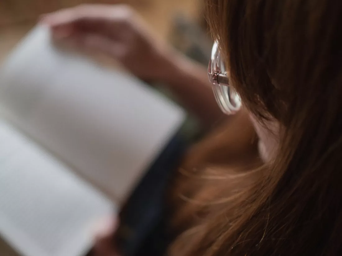 close-up-woman-reading-book-home