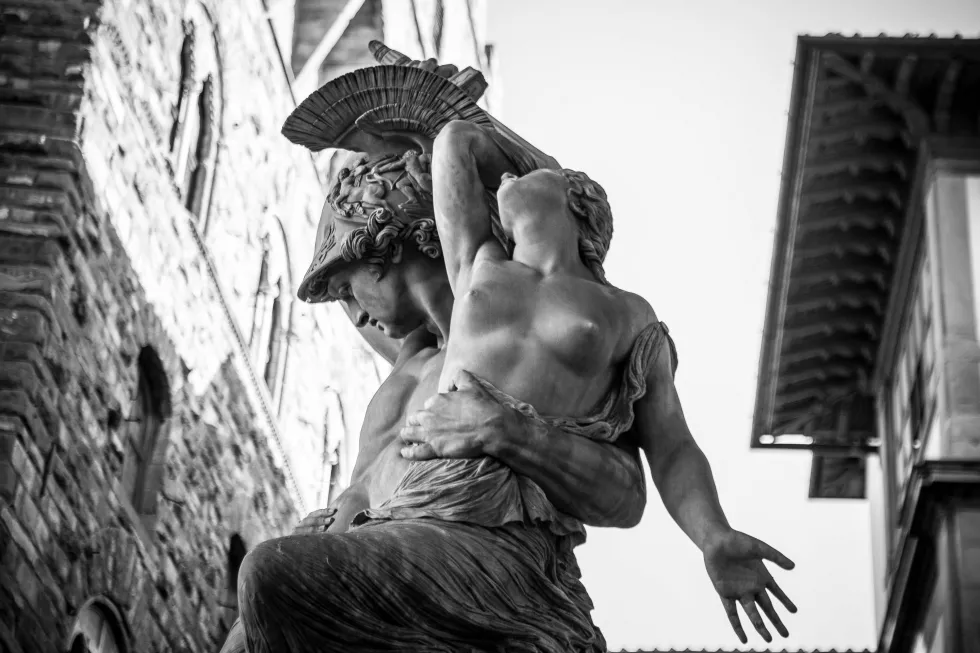 low-angle-view-male-female-statues-against-buildings