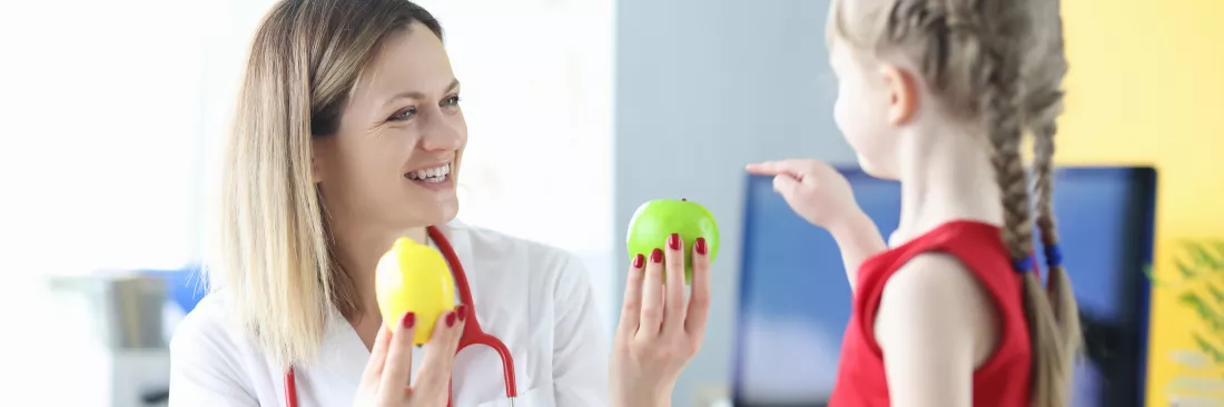 woman-doctor-giving-fruit-little-girl-clinic-proper-nutrition-children-concept