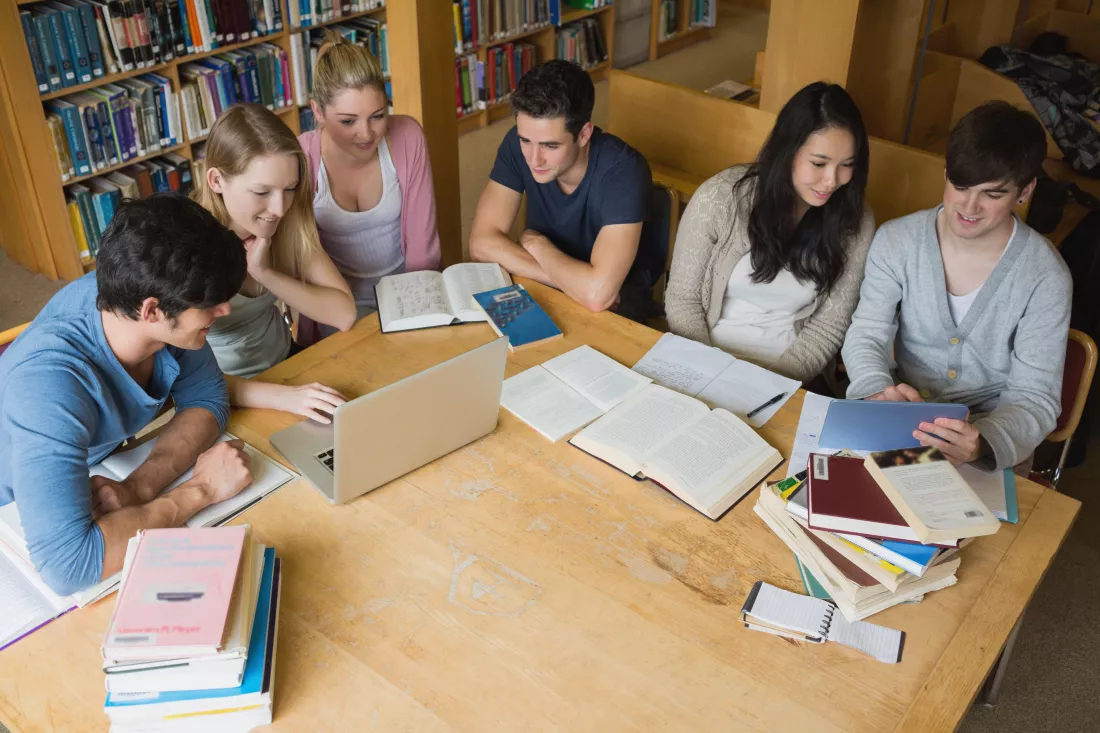 students-learning-with-laptop-tablet-library