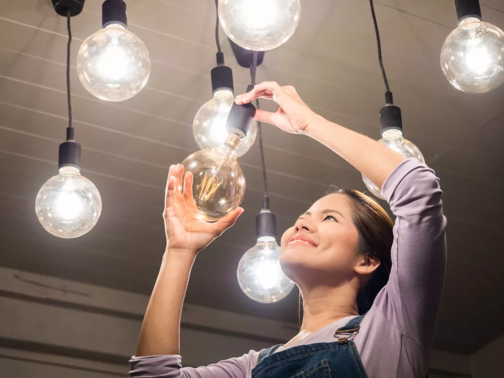 asian-woman-changing-light-bulb