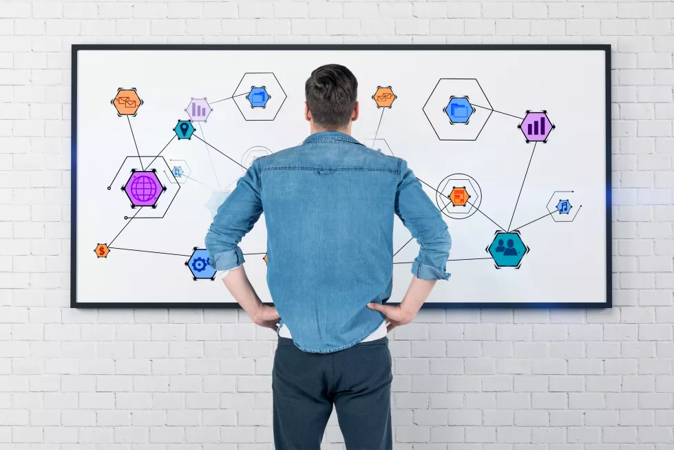 rear-view-caucasian-young-man-jeans-shirt-gray-pants-looking-whiteboard-with-colorful-internet-icons-it
