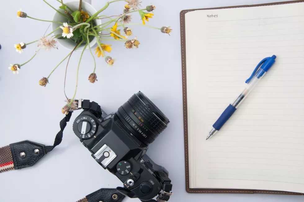 close-up-camera-with-flower-vase-diary-table