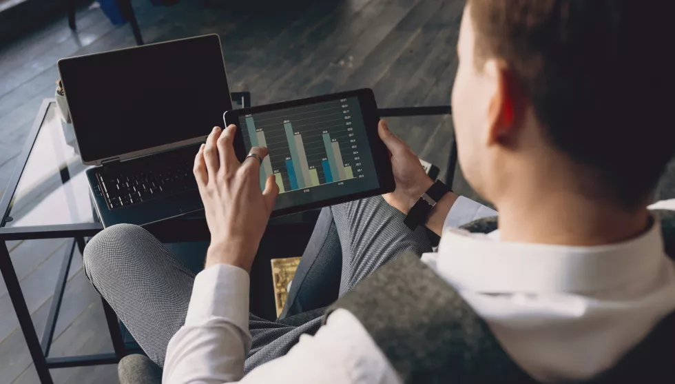 top-view-business-man-hand-holding-tablet-with-graphics-while-sitting-his-office