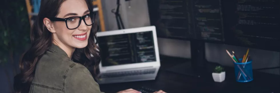 computer-programming-usmiechnieta-programistka-pisze-kod-przy-monitorach