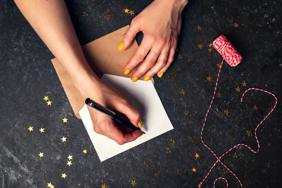 woman-writes-plans-2022-black-background-top-view