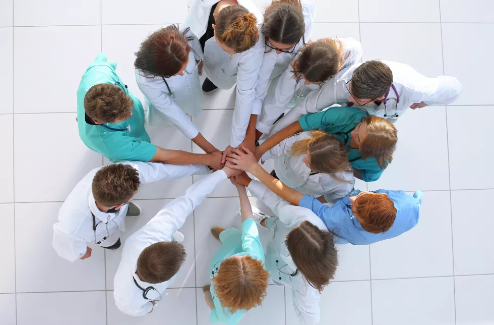 group-medics-standing-circle-joining-their-palms-together