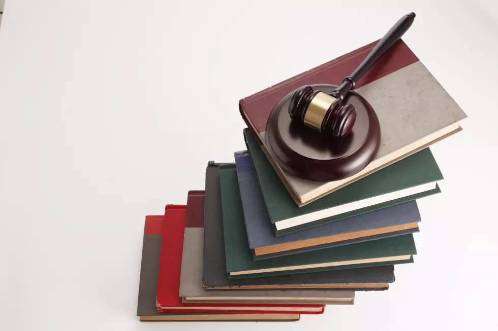 close-up-gavel-stacked-books-against-white-background