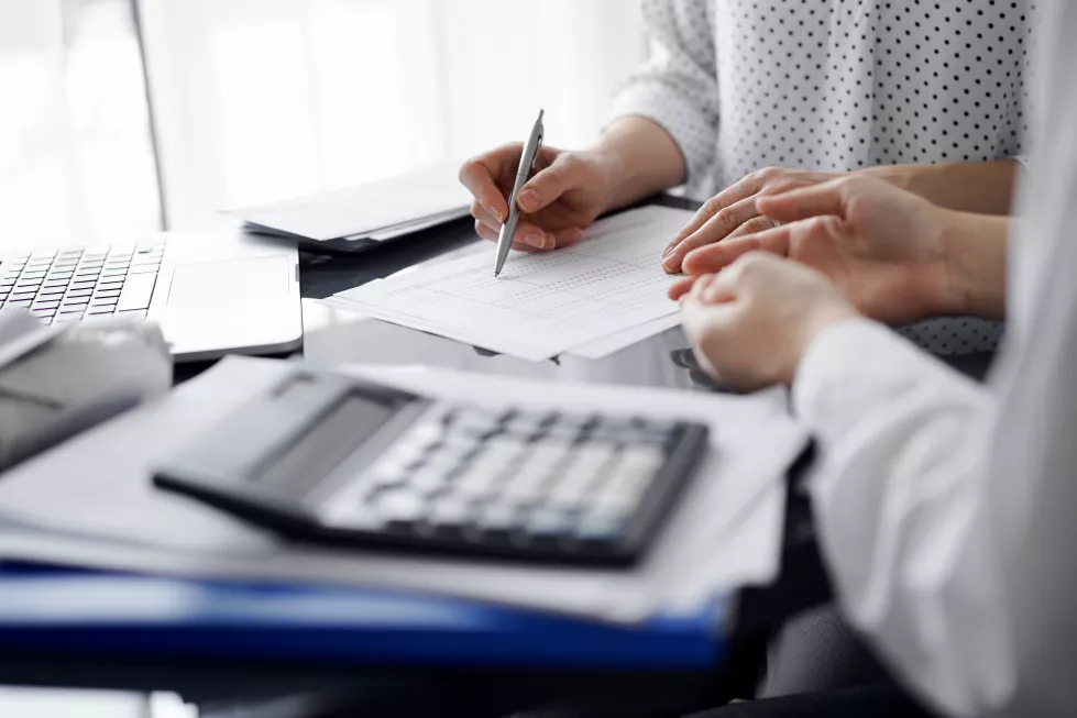 woman-accountant-using-calculator-laptop-computer-while-counting-taxes-client-business-audit-finance-concepts