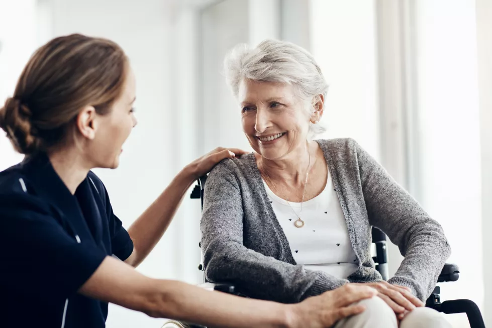 support-nurse-senior-woman-wheelchair-assistance-help-medical-care-retirement-home-discussion-friendly-caregiver-elderly-patient-with-disability-wellness-health-trust