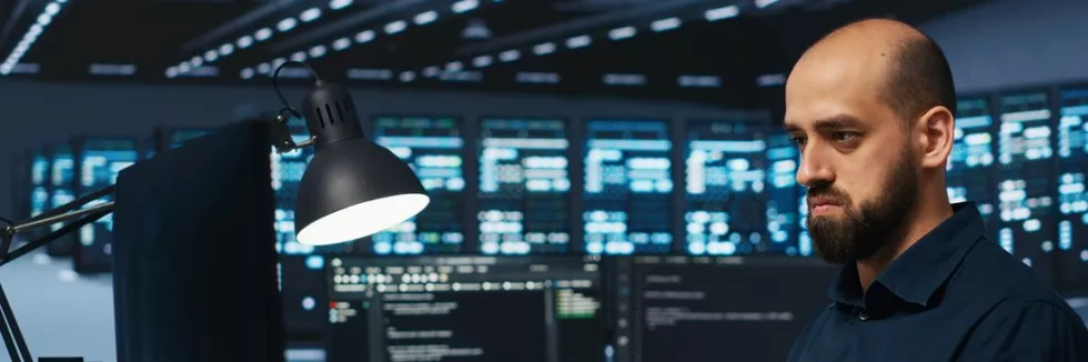 data-engineering-mlody-administrator-pracuje-przy-monitorach-w-centrum