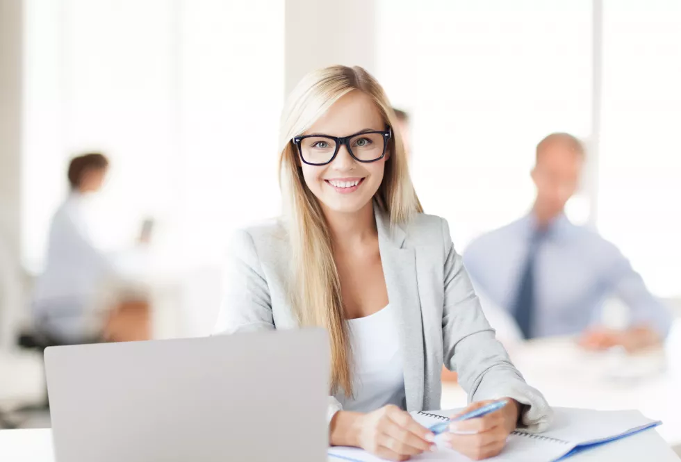 business-concept-smiling-woman-with-laptop-documents-pen-office