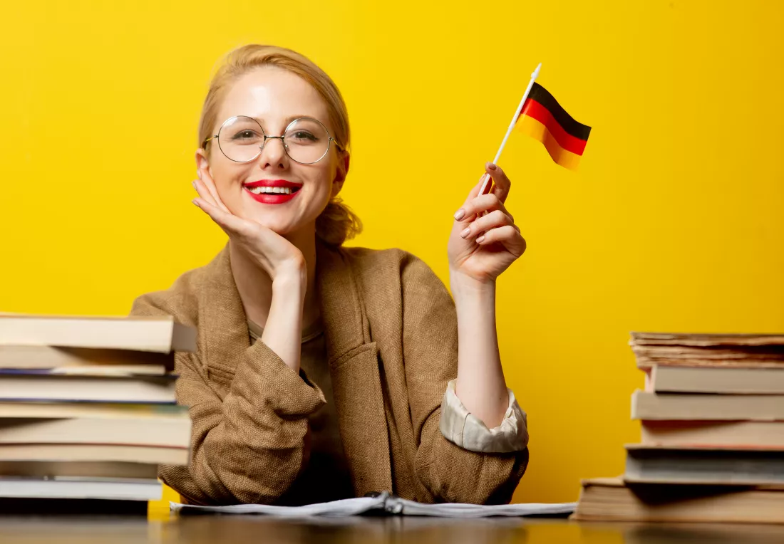 style-blonde-woman-sitting-table-with-books-flag-germany-yellow